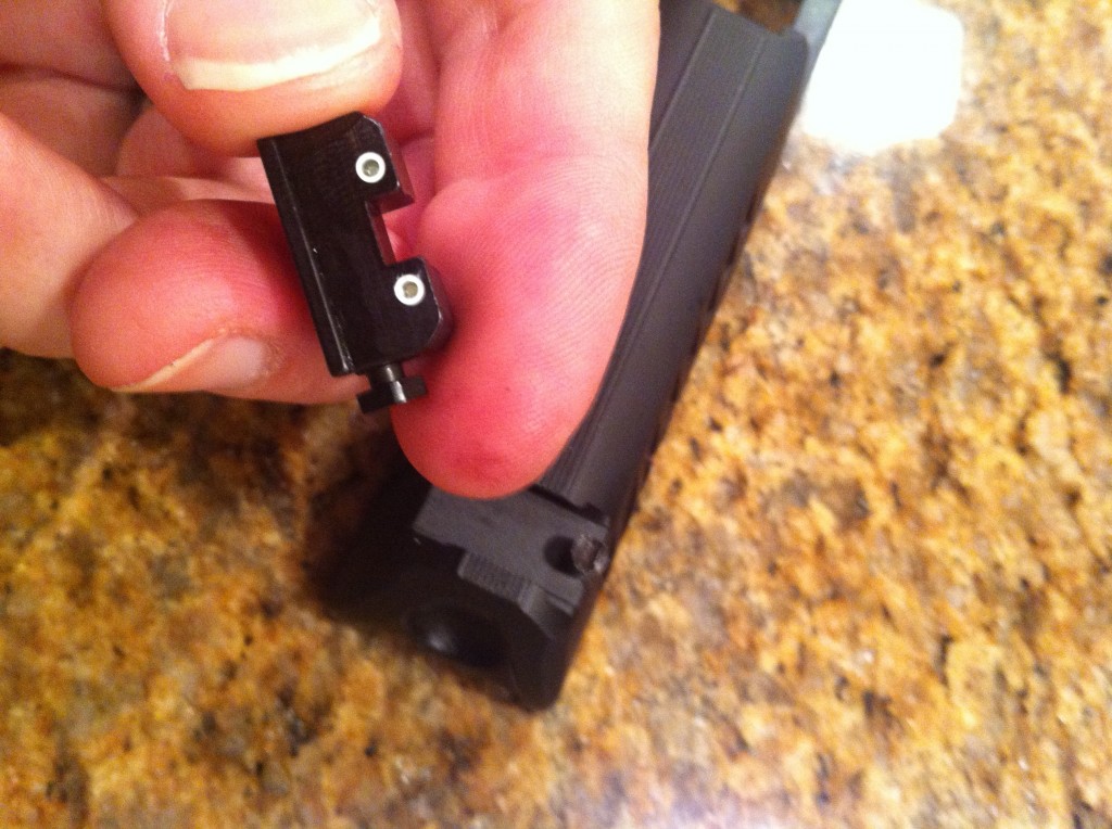 Stock adjustment screw inserted into Trijicon rear sight