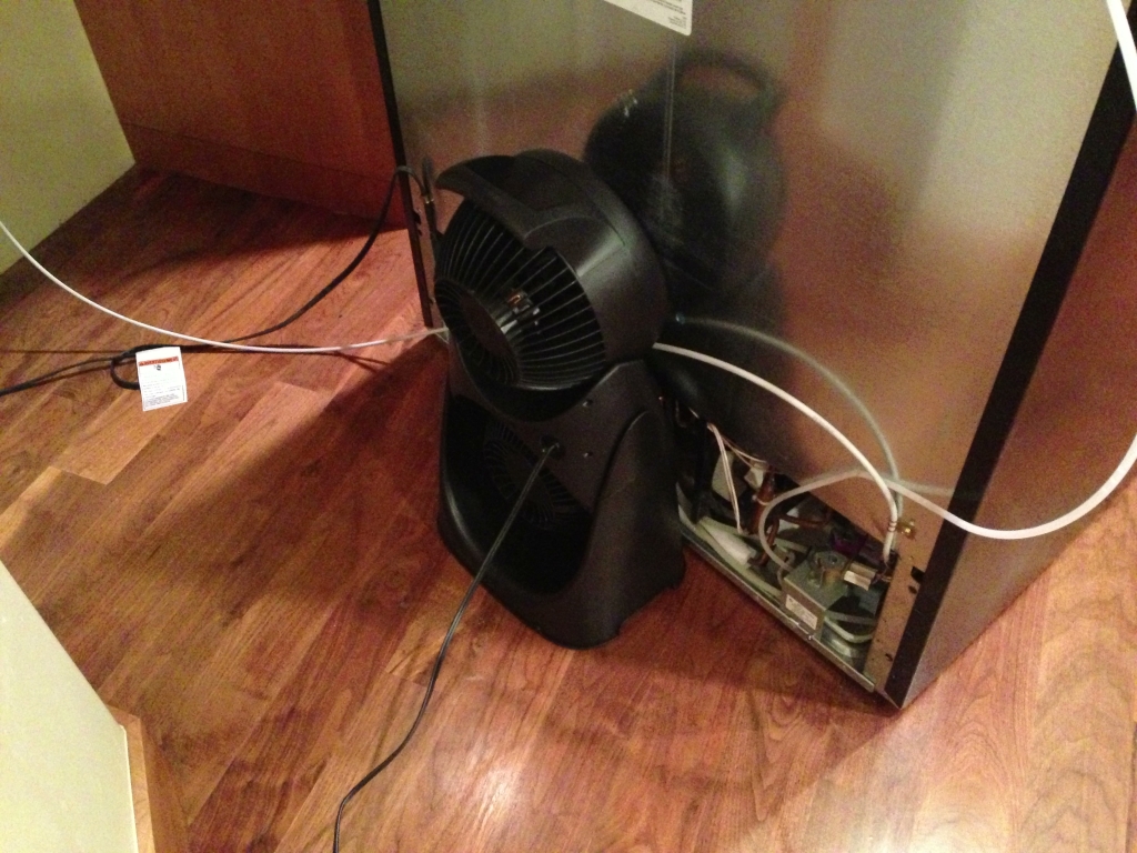 Floor fan blowing air across the condenser coils